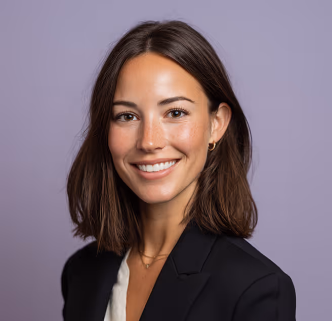 Une femme en tenue formelle au sourire assuré, image de professionnalisme et de confiance dans les services de recrutement.
